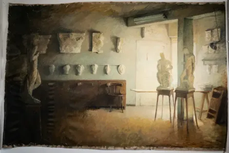 Interior de un estudio de arte con esculturas, moldes de yeso y brillante luz natural.
