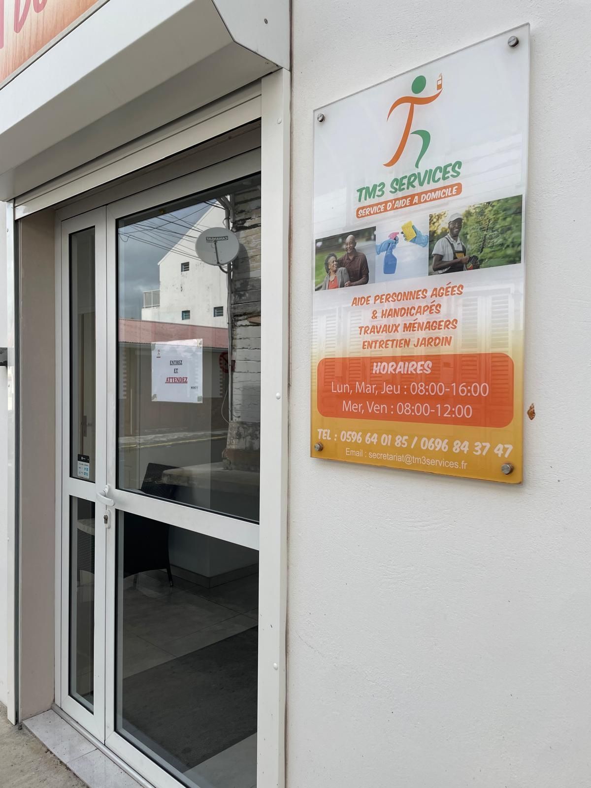 Femme souriante, les bras croisés, portant un pull foncé et un jean, sur fond blanc