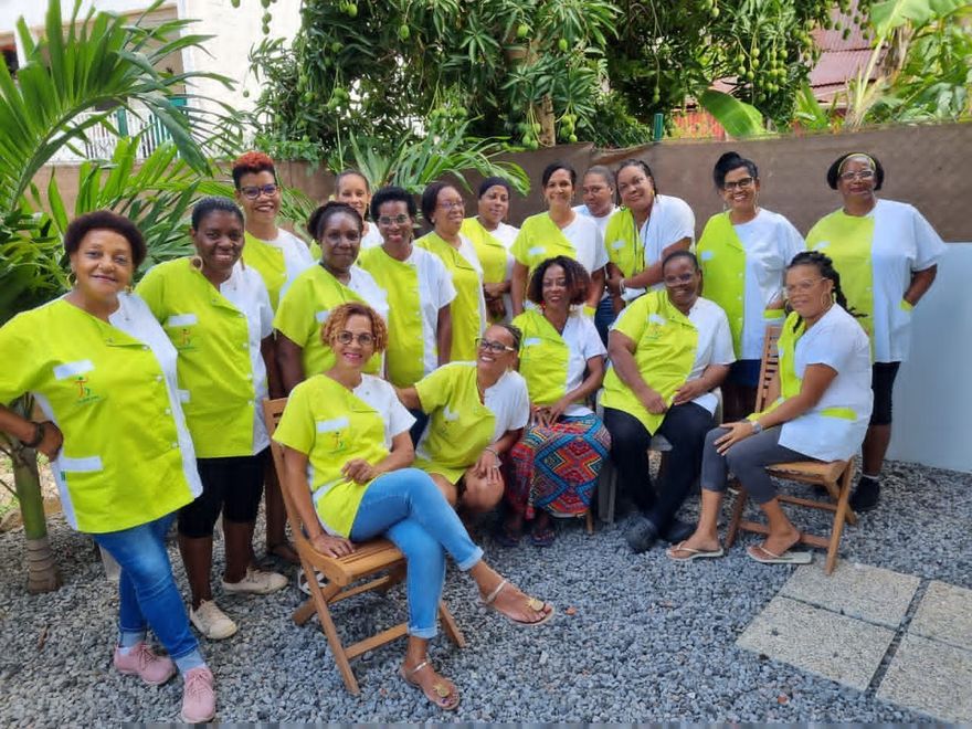 Un groupe de personnes vêtues de chemises jaune fluo pose à l'extérieur, dans une cour de jardin.