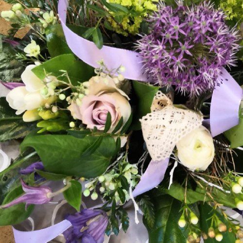 Blumengesteck mit lilafarbener Dekoration