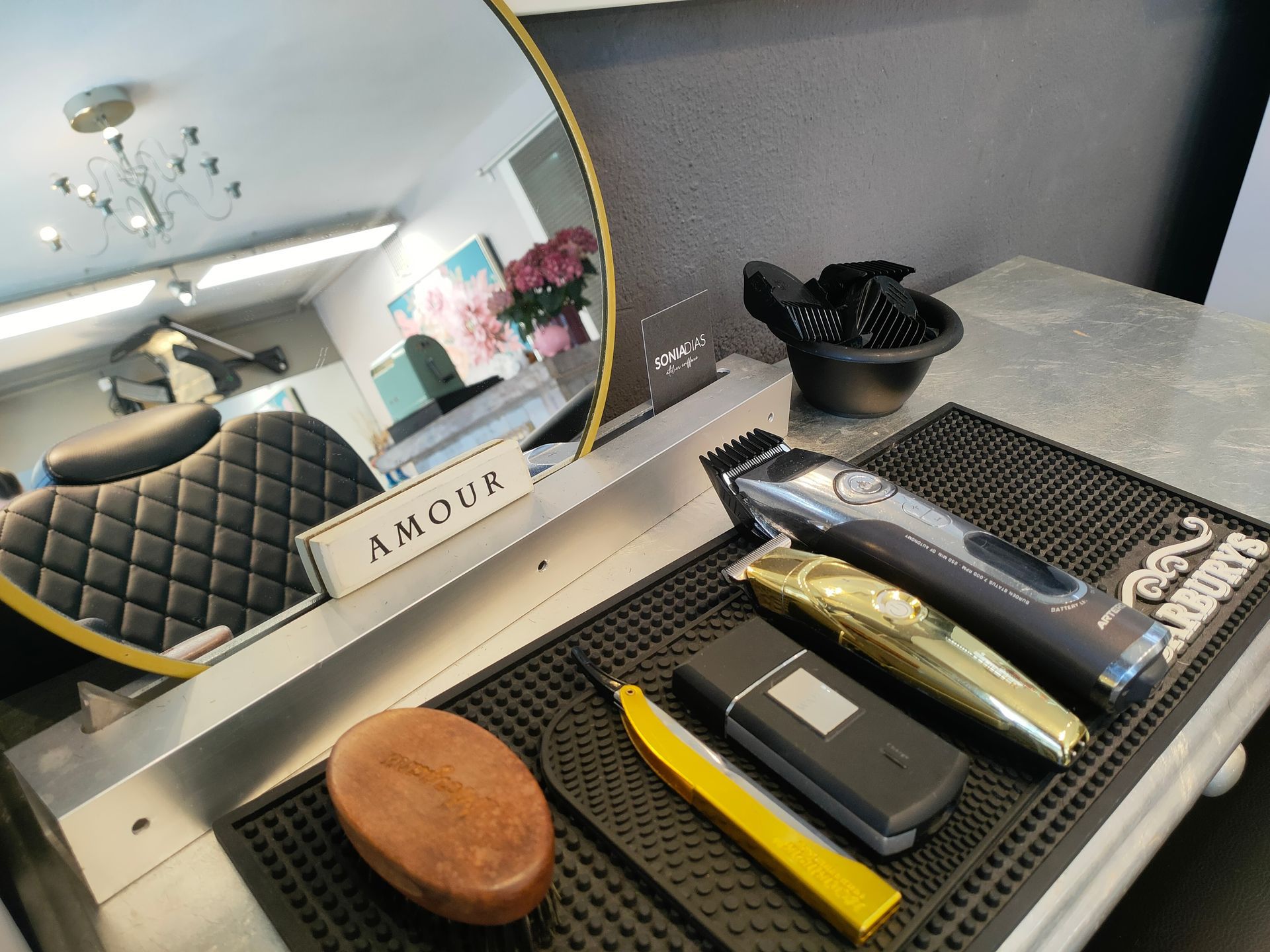 Drei Tassen Cappuccino stehen auf einem Holztisch neben Topfpflanzen.