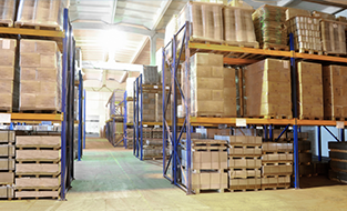 Interior de almacén con estantes repletos de productos envasados.