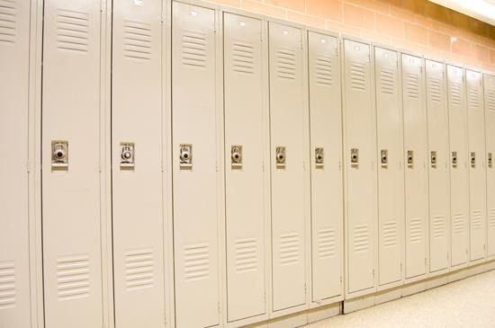 Fila de casilleros escolares de metal de color beige en un pasillo.