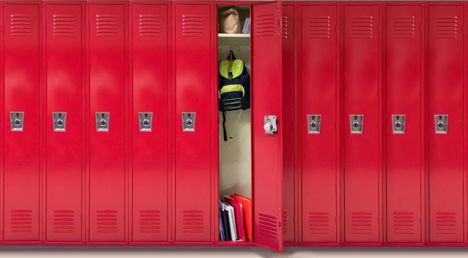 Fila de casilleros escolares rojos, una mochila abierta y reveladora y libros.