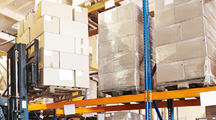 Carretilla elevadora colocando cajas en un estante del almacén.