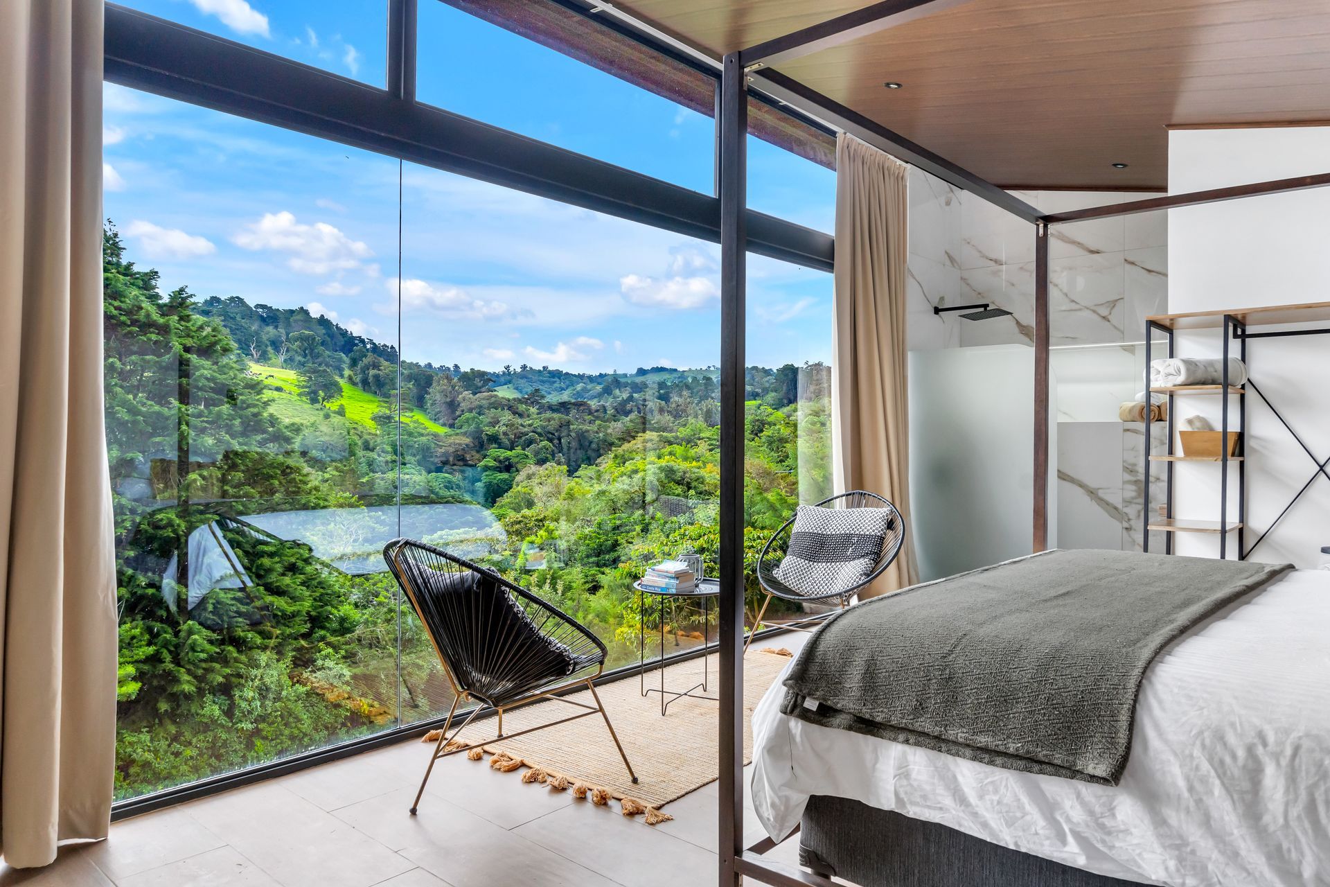 A bedroom with a canopy bed and a view of a lake.