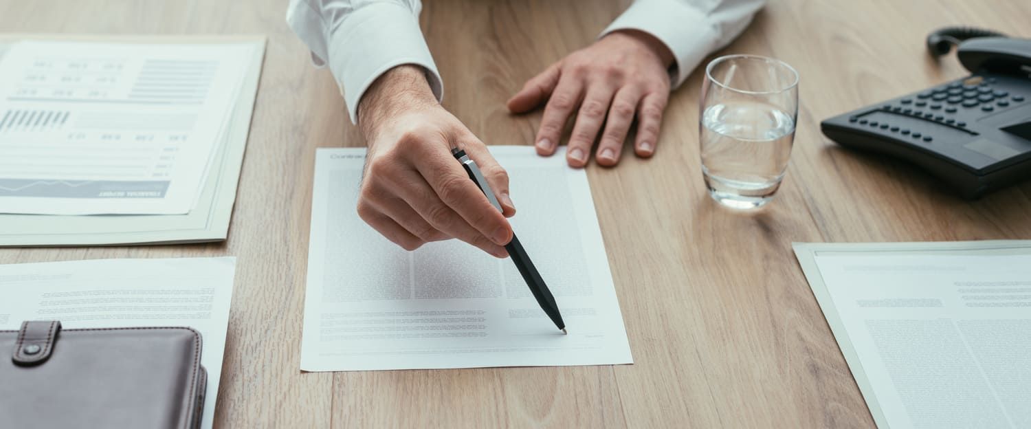 Una persona está escribiendo en un trozo de papel con un bolígrafo.