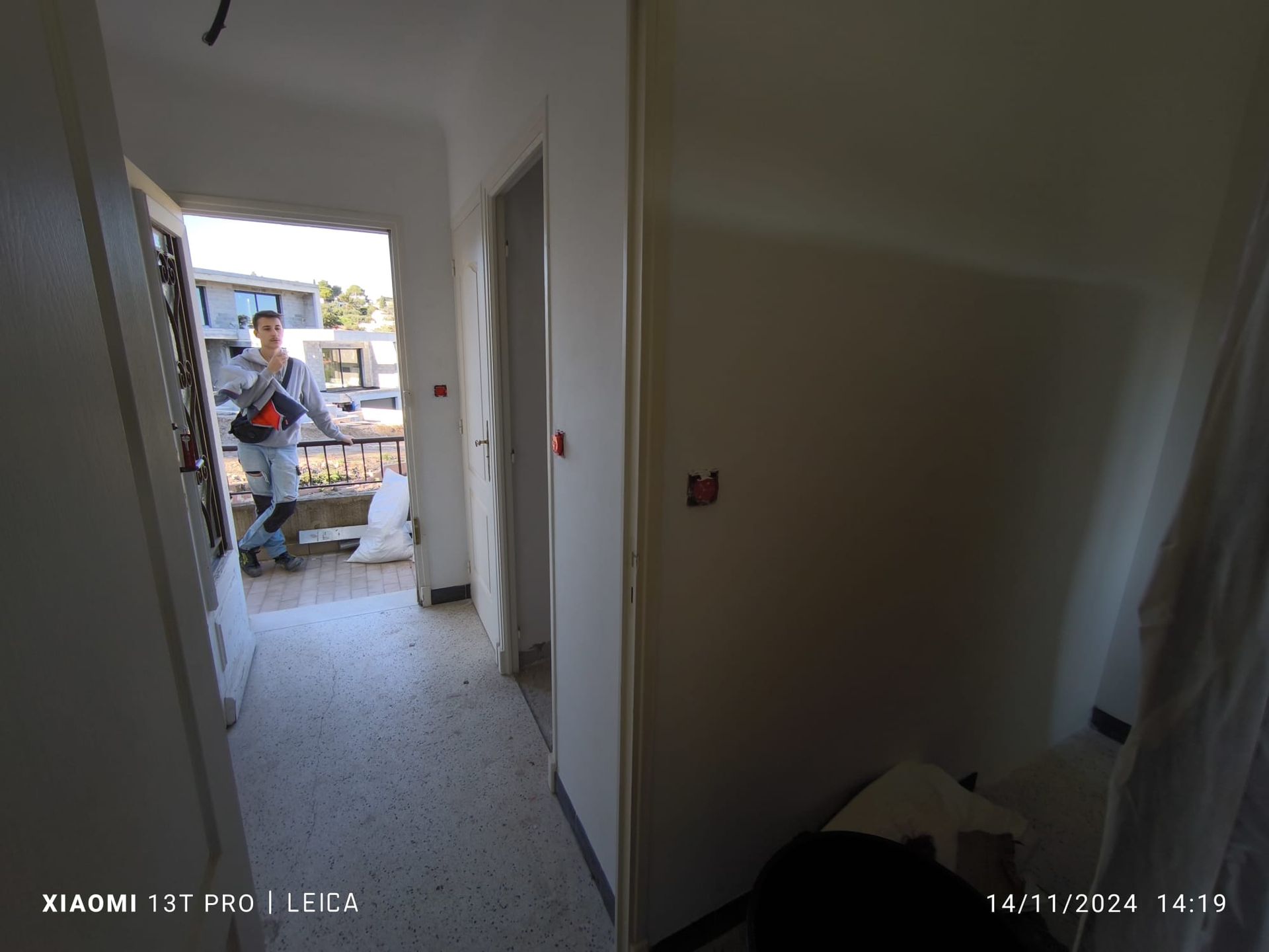 Porte ouverte d'un appartement donnant sur l'extérieur