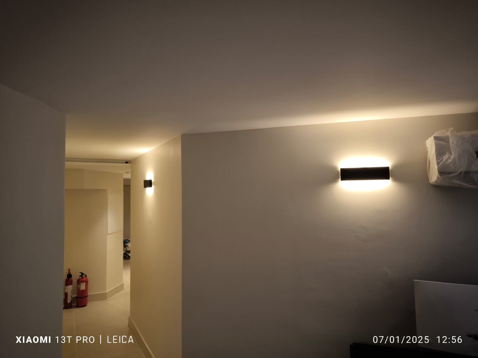 Luminaire noir allumé dans un couloir