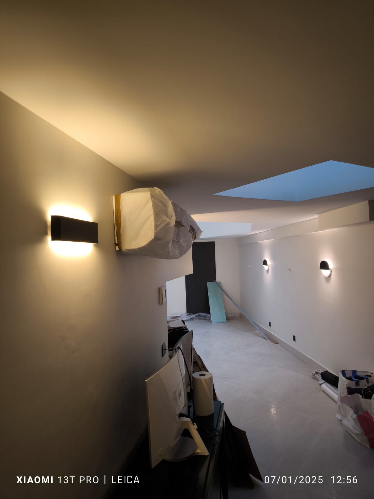 Installation de luminaires sur les murs d'un couloir