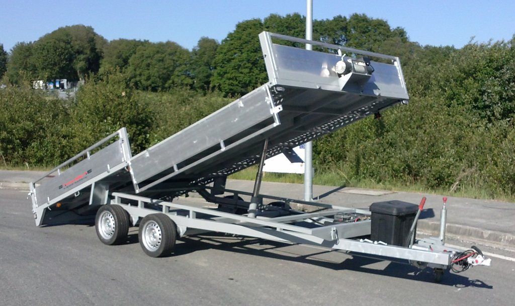 Un remolque plateado está estacionado al costado de la carretera.