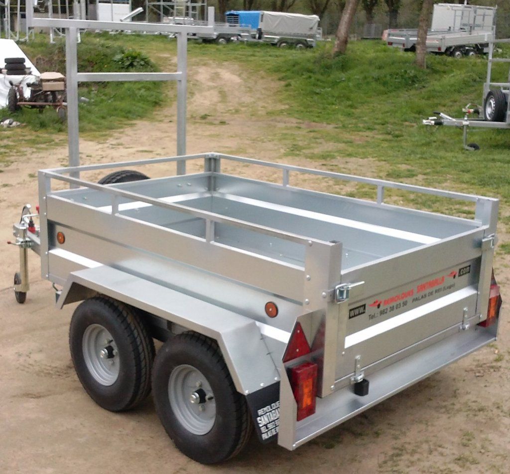 Un remolque con portaequipajes está estacionado en un camino de tierra