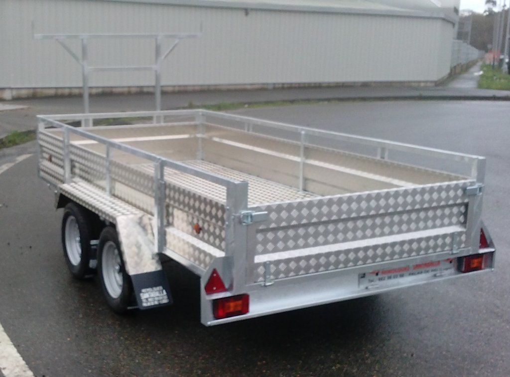 Un remolque plateado está estacionado al costado de la carretera.