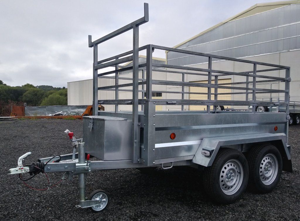 Un remolque está estacionado en un lote de grava frente a un edificio.