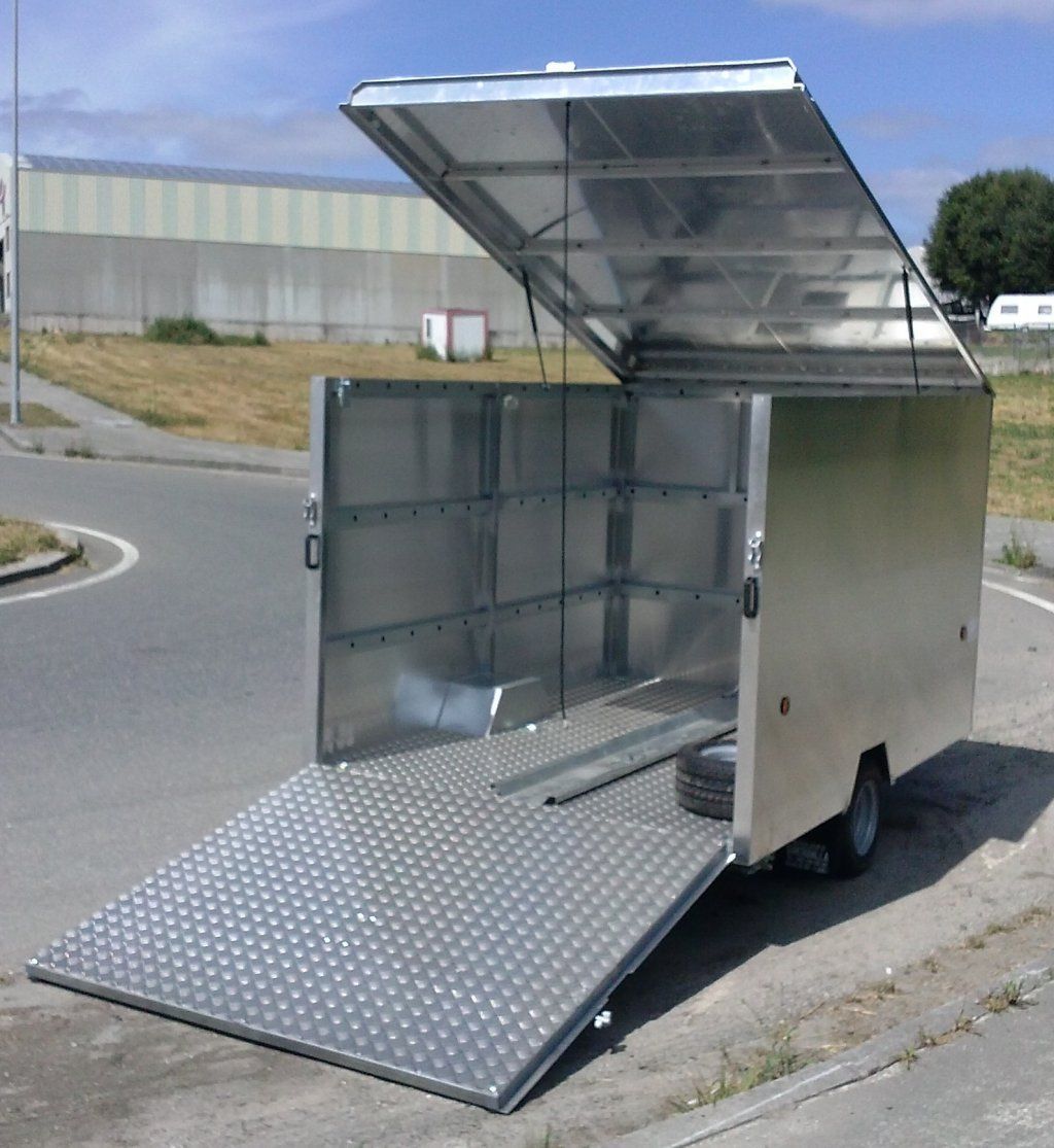 Un remolque con la tapa abierta está estacionado al costado de la carretera