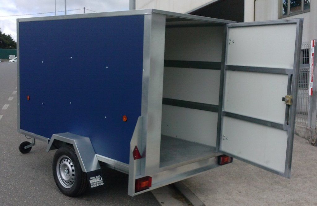 Un remolque azul y blanco con las puertas abiertas.