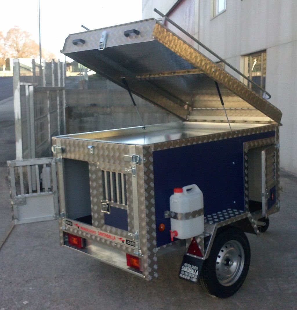 Un remolque azul y plateado con la tapa abierta.