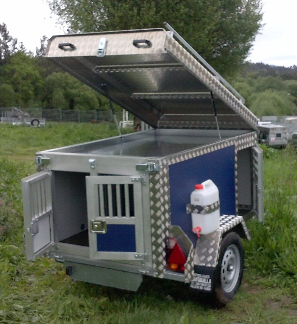 Un remolque azul y plateado con la tapa abierta.