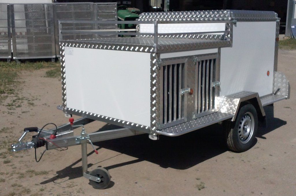 Un remolque blanco con una jaula encima.