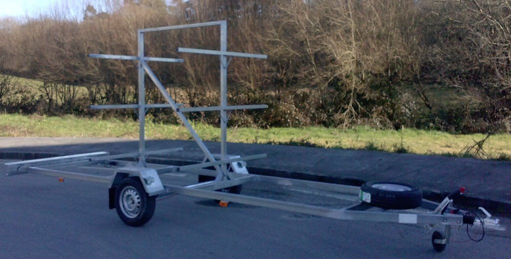 Un remolque con un portaequipajes está estacionado al costado de la carretera.