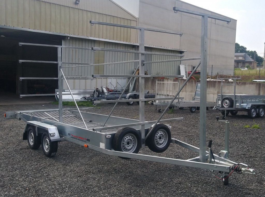 Un remolque está estacionado en un lote de grava frente a un edificio.