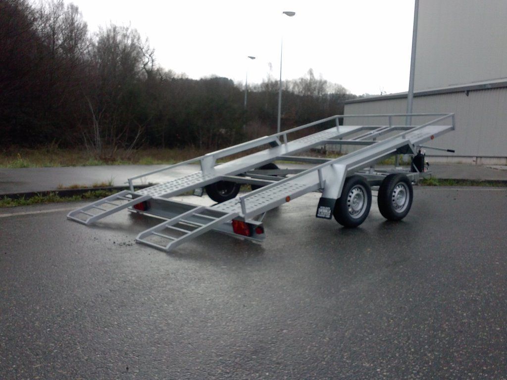 Un remolque de automóvil está estacionado al costado de la carretera.
