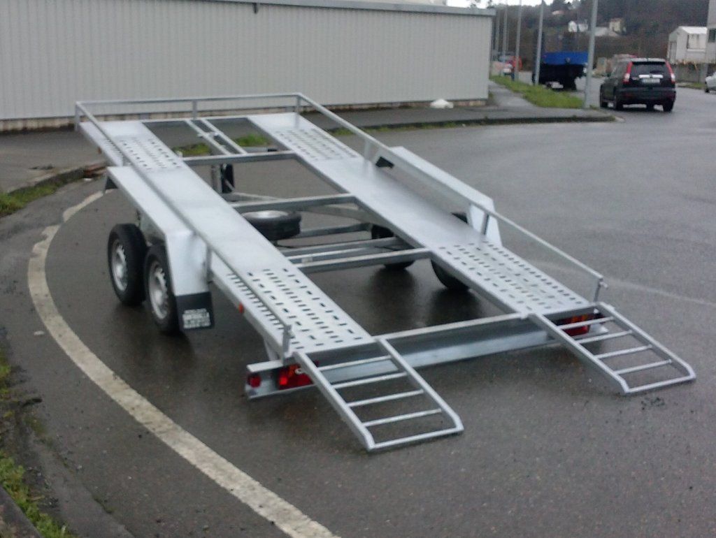 Un remolque de automóvil está estacionado al costado de la carretera