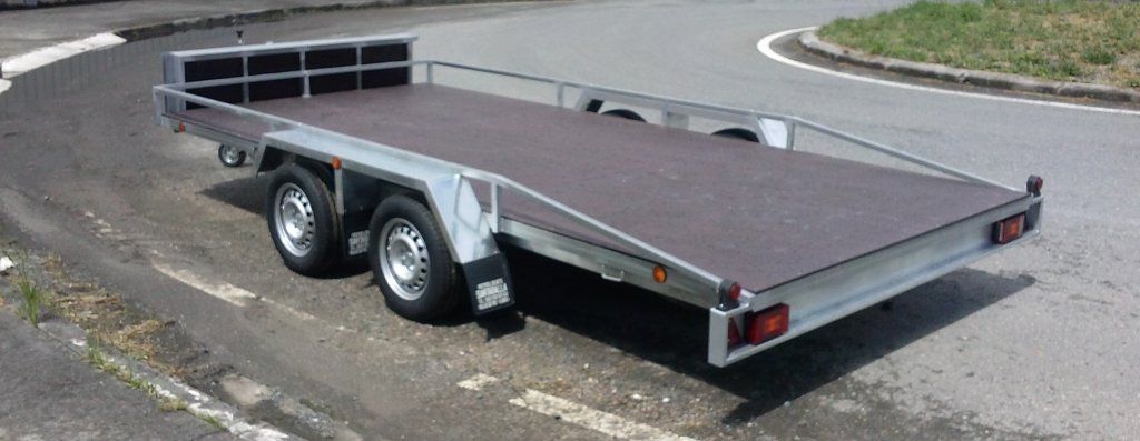 Un remolque de plataforma está estacionado al costado de la carretera.