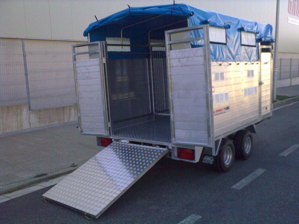 Un remolque con una lona azul encima está estacionado al costado de la carretera.