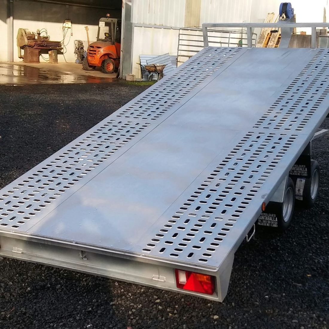 Un gran remolque de acero inoxidable está estacionado en un estacionamiento.