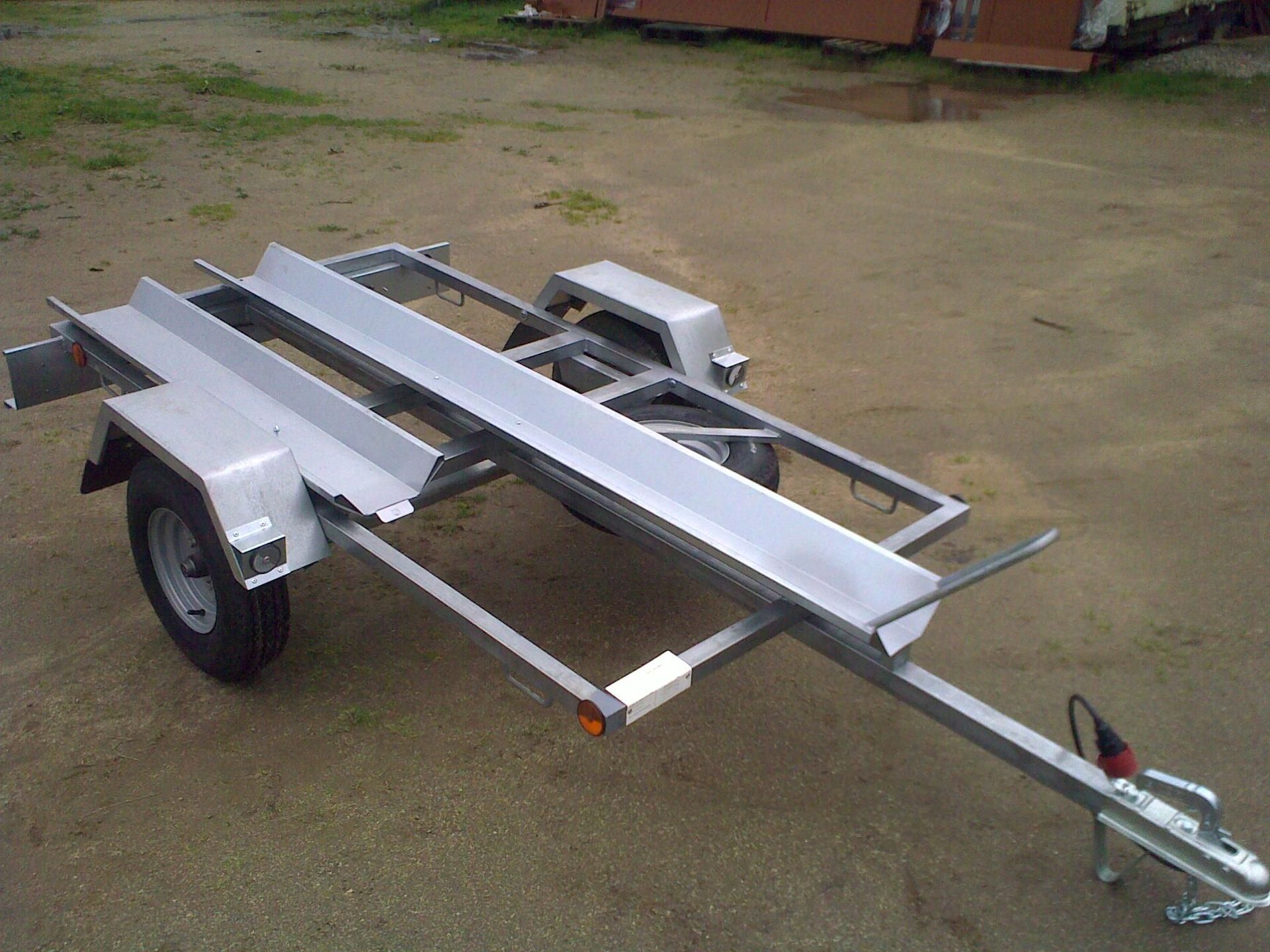 Un remolque de motocicleta está estacionado en un campo de tierra