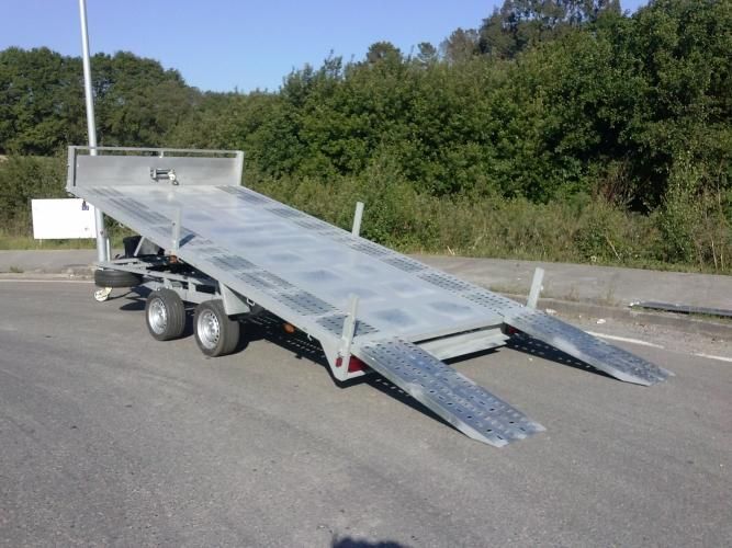 Un remolque de plataforma está estacionado al costado de la carretera.