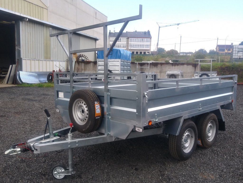 Un remolque está estacionado en un lote de grava frente a un edificio.