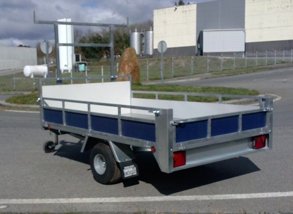 Un remolque azul y blanco está estacionado en un estacionamiento.