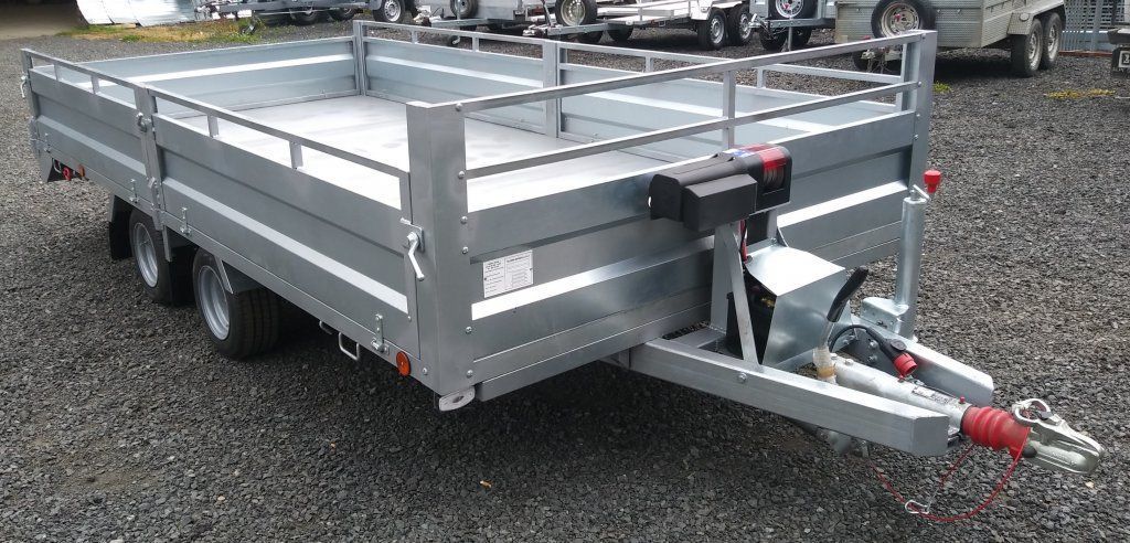 Un remolque plateado está estacionado en un lote de grava.