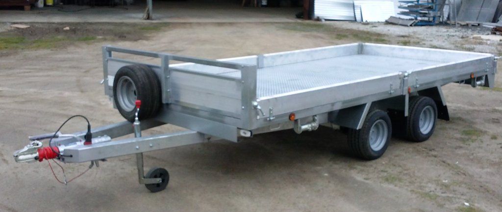 Un remolque de plataforma está estacionado en un lote de tierra.