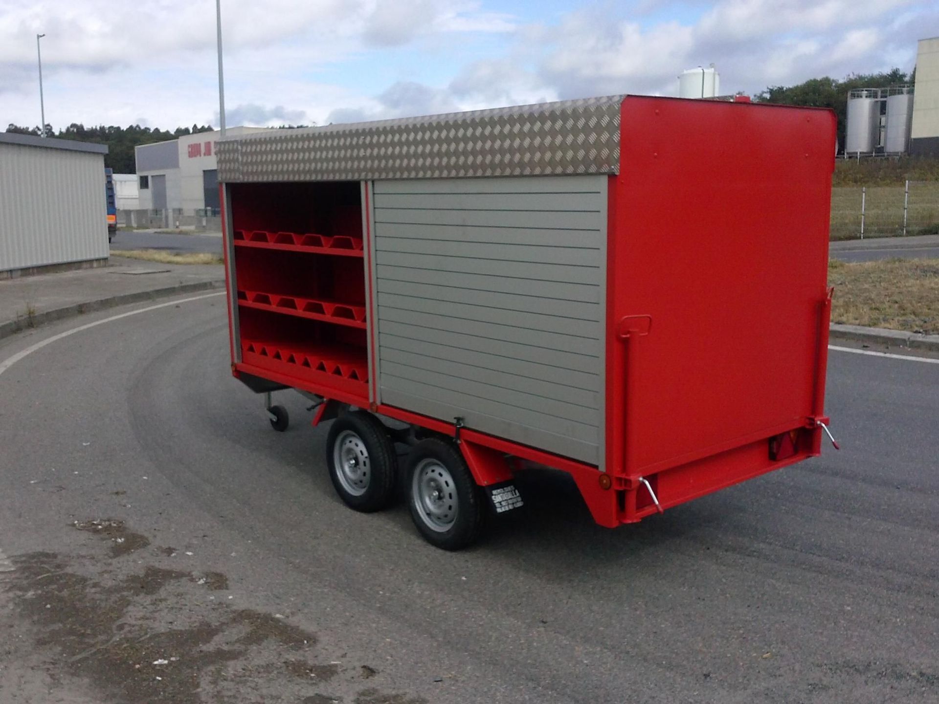 Un remolque rojo está estacionado al costado de la carretera.