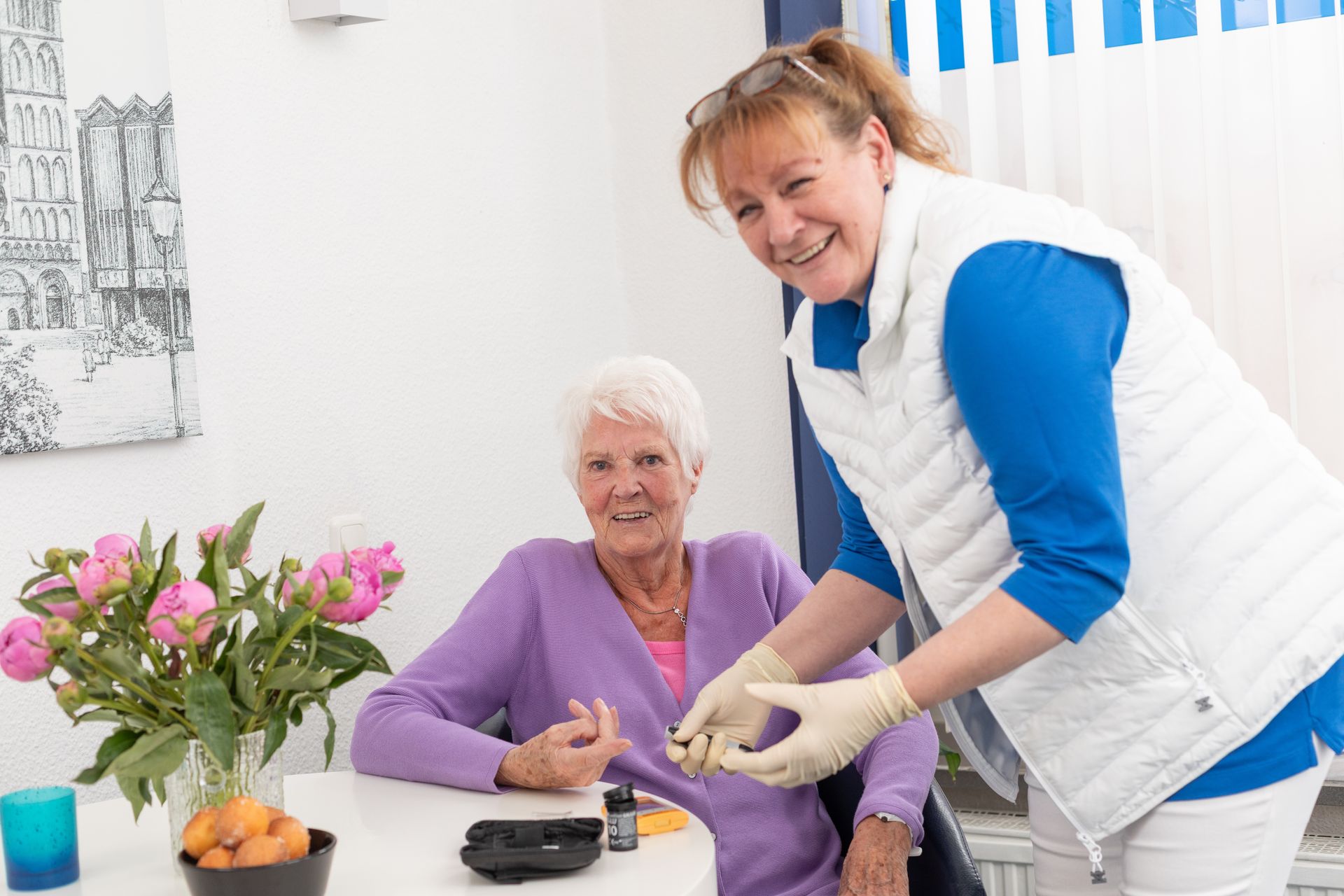 Eine Krankenschwester hält in einem Pflegeheim die Hand eines älteren Mannes.