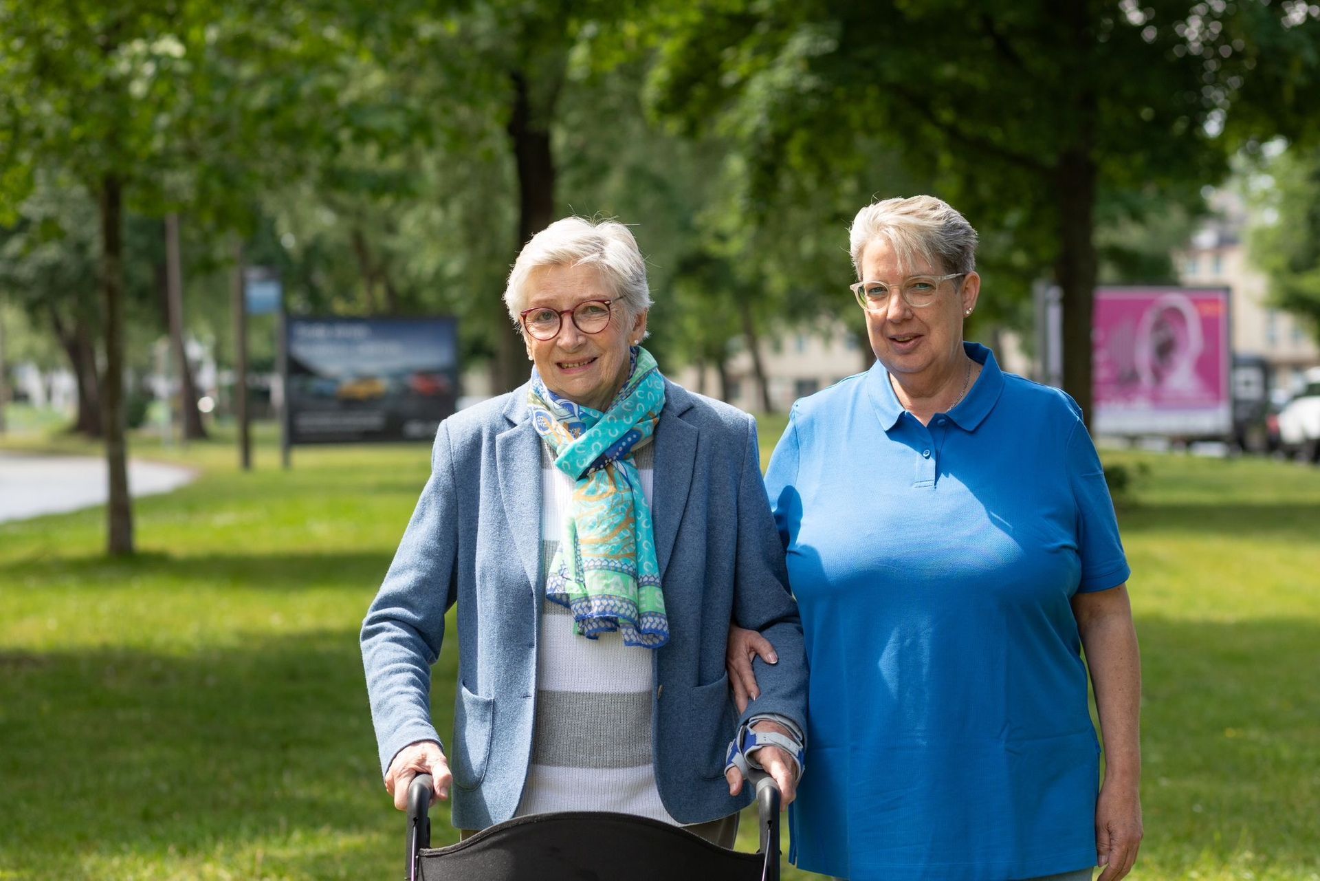 Eine Krankenschwester hilft einer älteren Frau im Rollstuhl.