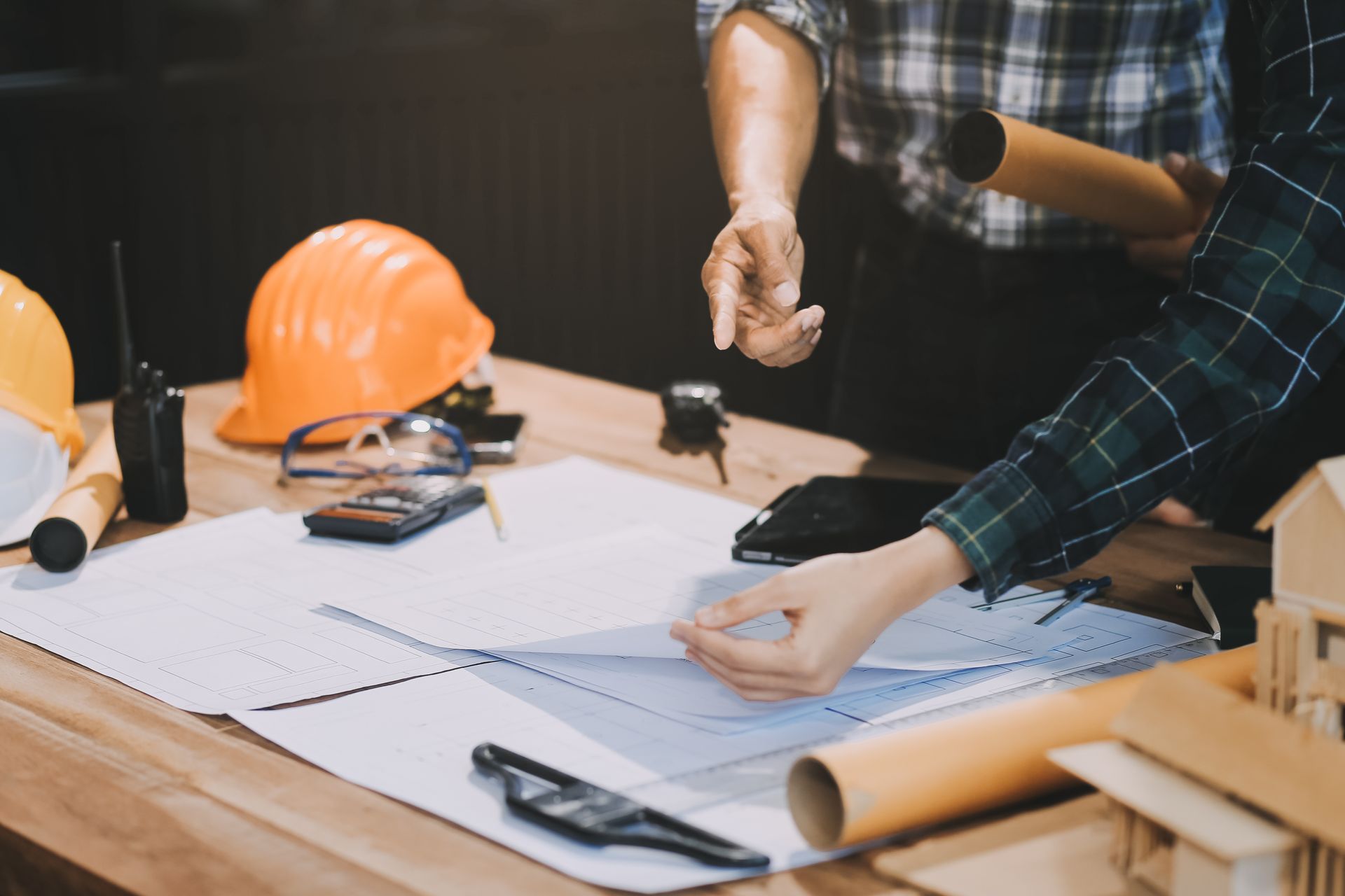 Un gruppo di operai edili è seduto a un tavolo e guarda una planimetria.