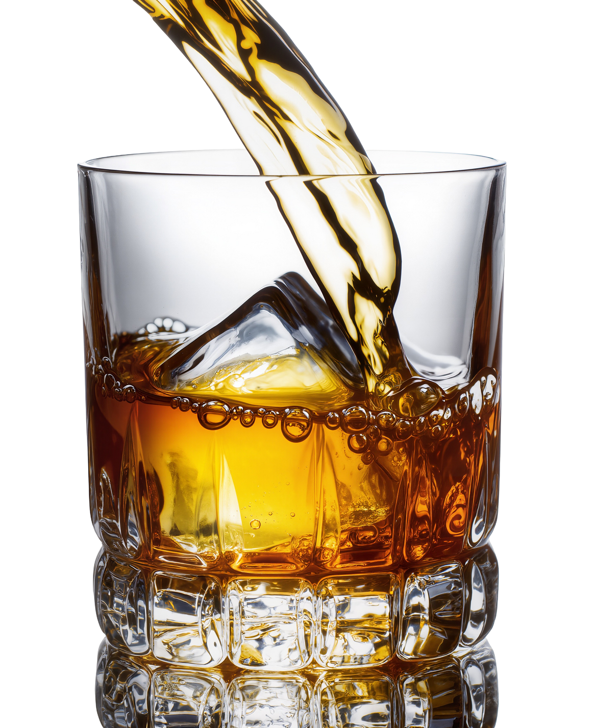 Du whisky est versé dans un verre à whisky rempli de glace.