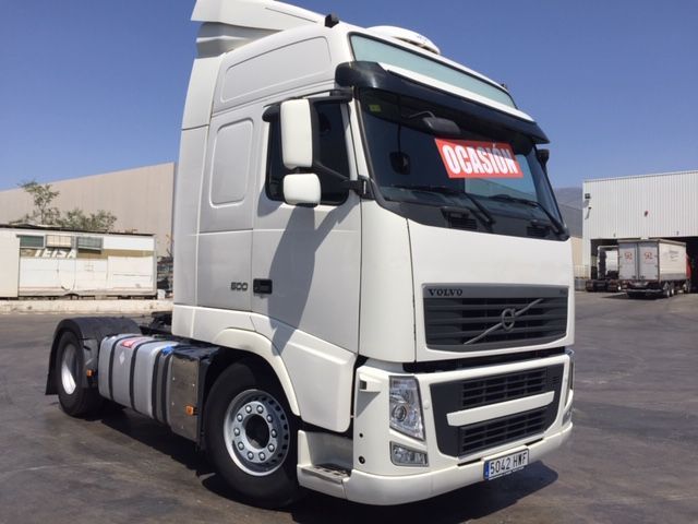 Un camión semirremolque Volvo blanco está estacionado en un estacionamiento.