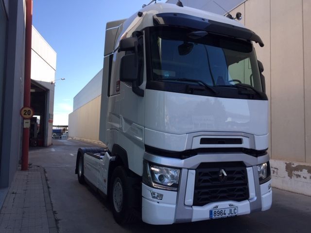 Un camión blanco está estacionado frente a un edificio.