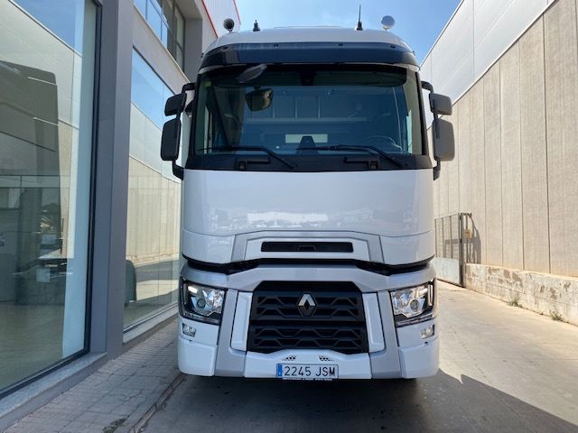 Un camión blanco está estacionado frente a un edificio.