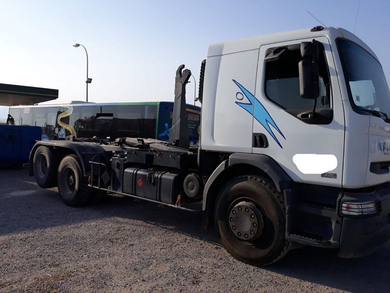 Un camión volquete blanco está estacionado en un lote de grava.