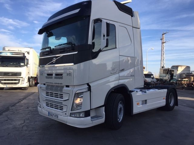 Un camión semirremolque blanco está estacionado en un estacionamiento.