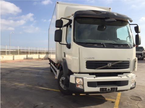 Un camión Volvo blanco está estacionado en un estacionamiento.