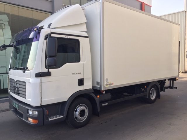 Un camión de un hombre blanco está estacionado frente a un edificio.