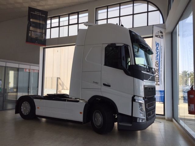 Un camión semirremolque blanco está estacionado en una sala de exposición.