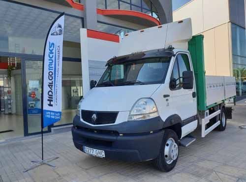 Un camión blanco está estacionado frente a un edificio.